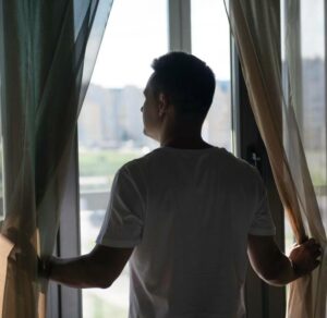portrait of man with curtains and shadows from window