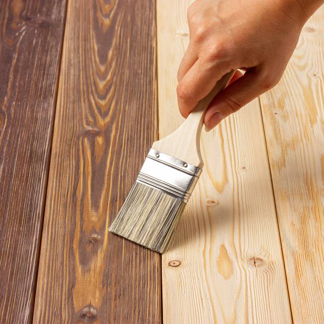 painting wood preserver on wood planks